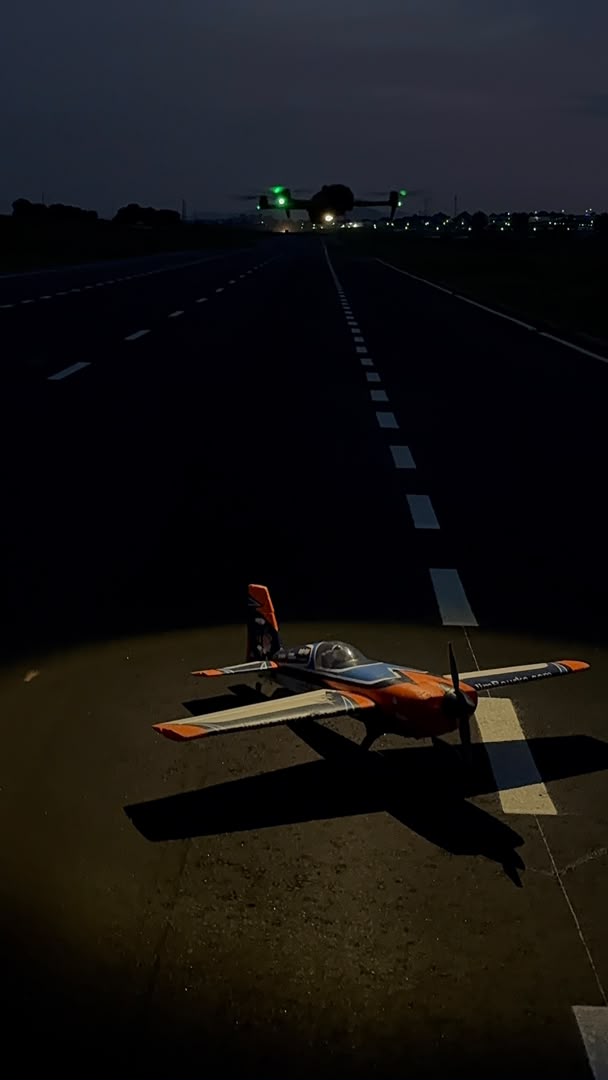 RC aircraft lit on the runway at dusk