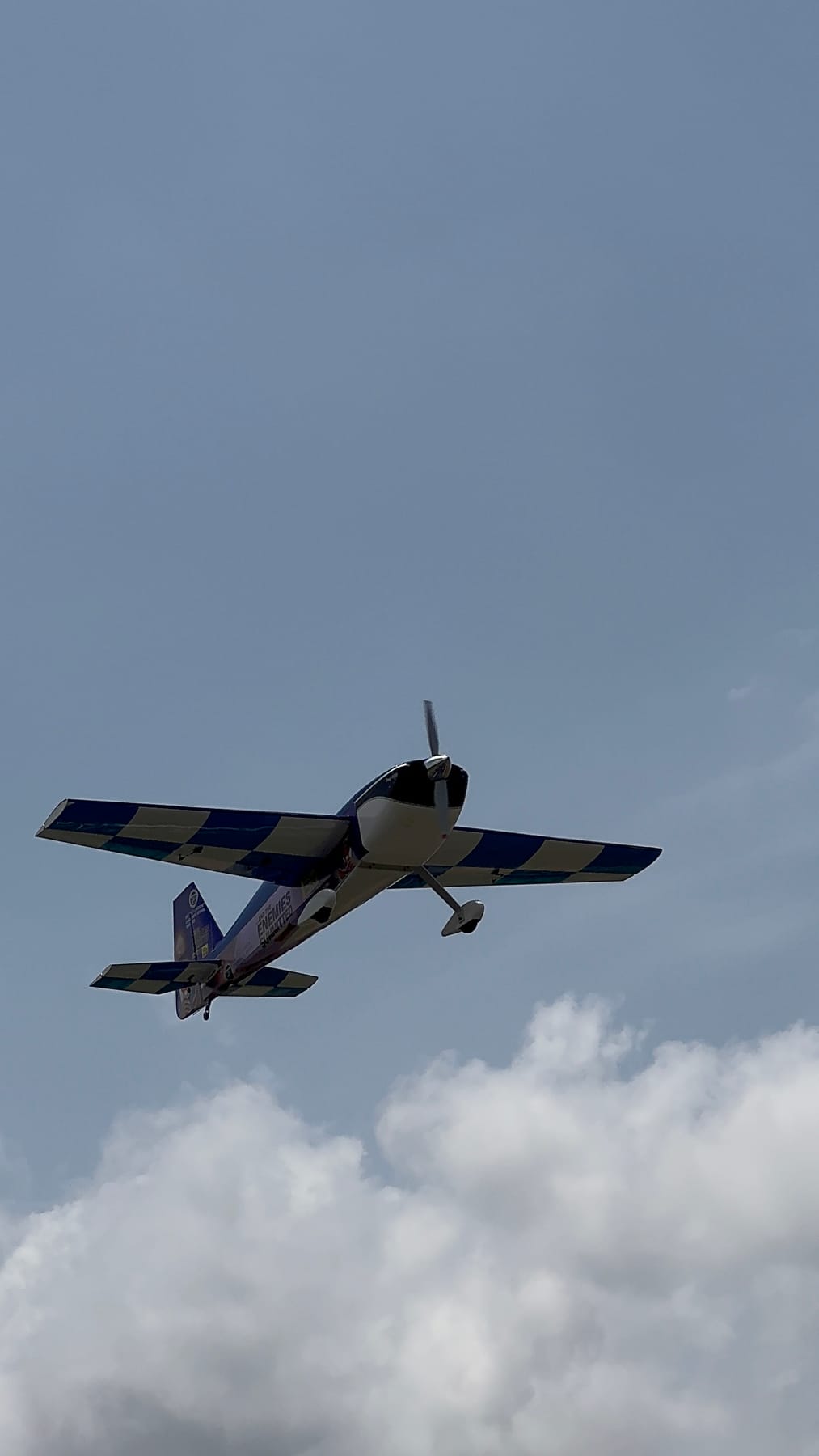 RC aircraft banking through a blue sky