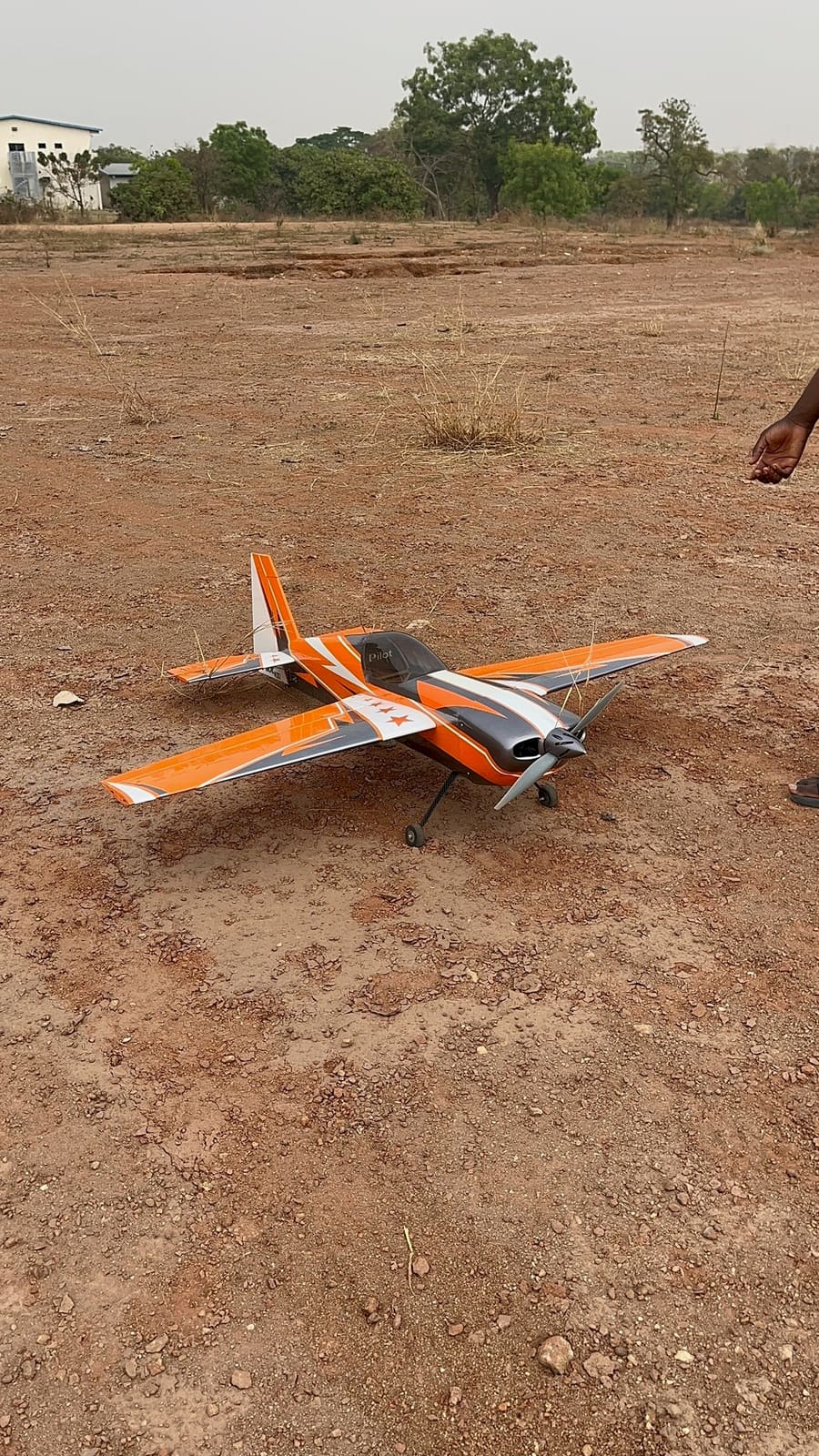 Orange and white aerobatic RC plane on the ground before a flight