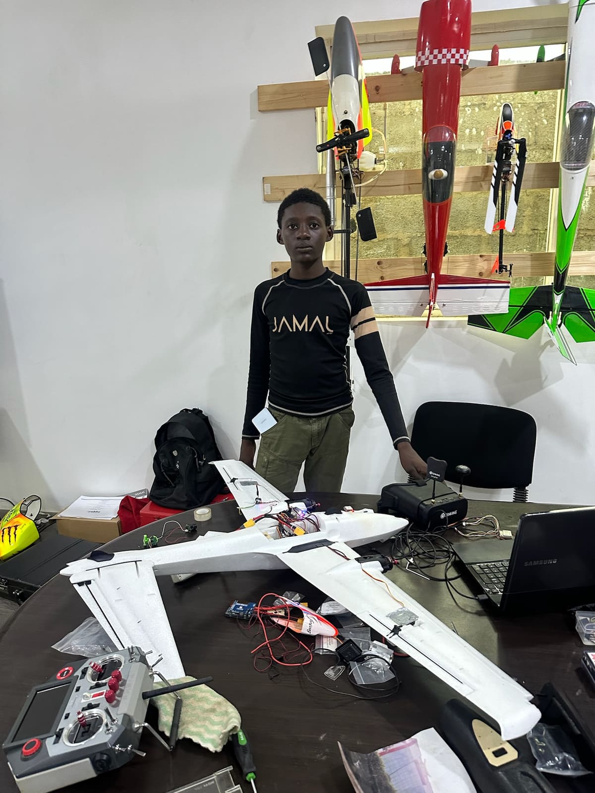 Young builder with an FPV aircraft build at the workshop bench