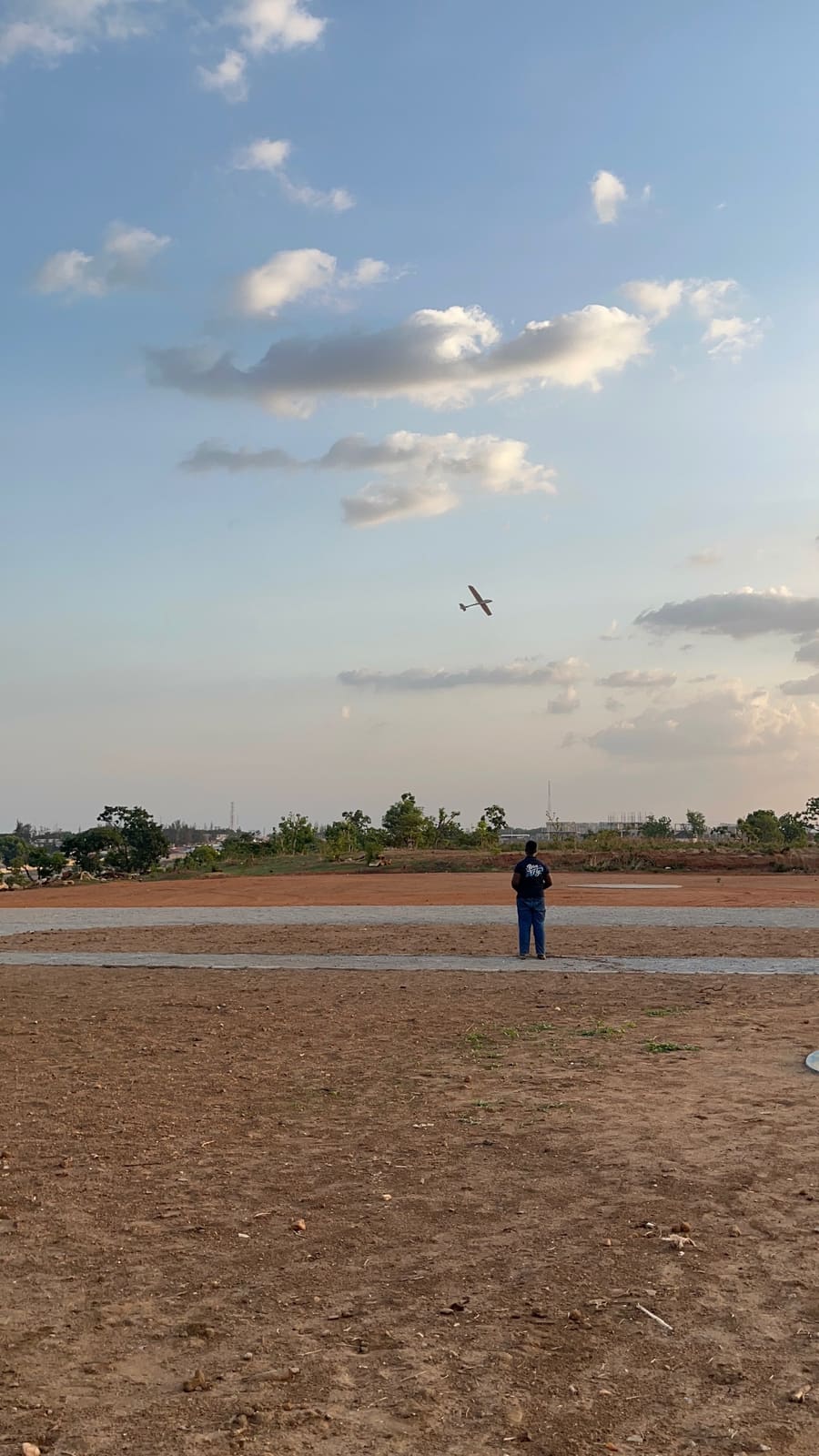 Pilot tracking an RC aircraft across a clear blue sky